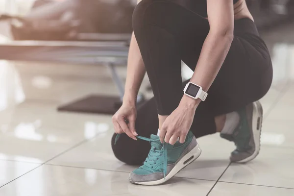 Mujer activa atándose los cordones de los zapatos después del entrenamiento — Foto de Stock