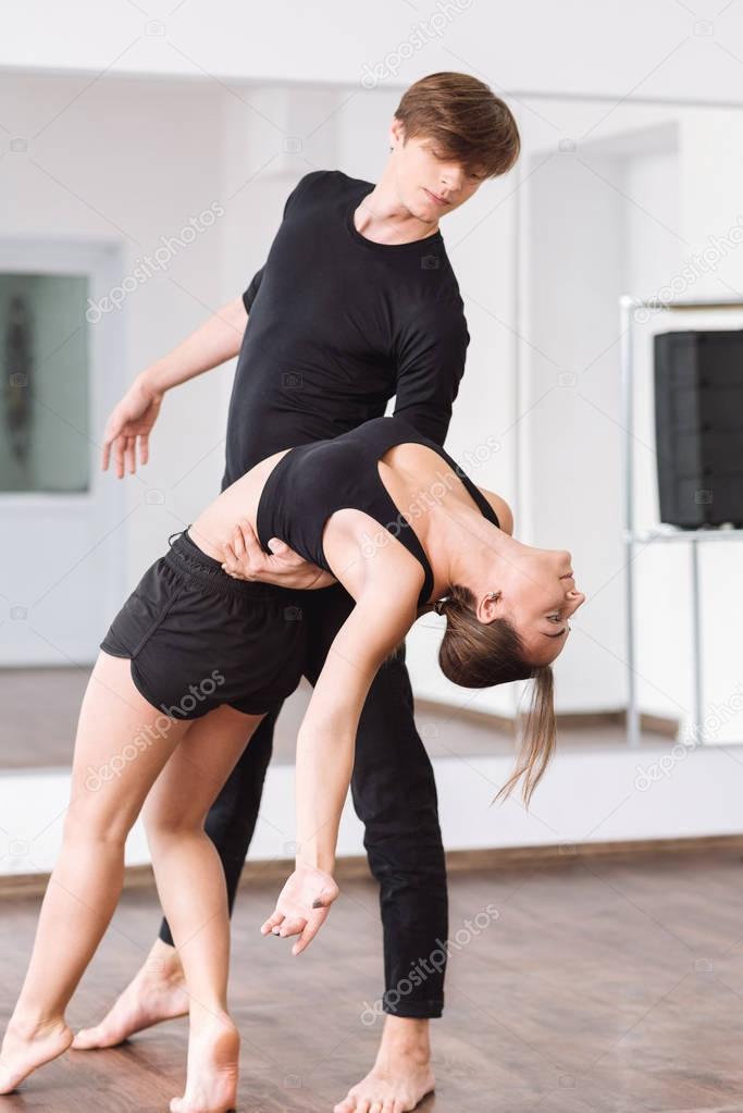 Strong masterful man holding the back his female partner