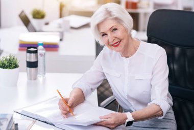 Gülümseyen iş kadını ofiste onun sorumlulukları yerine yaşlı