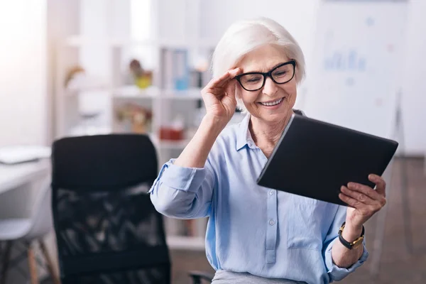 Blij leeftijd zakenvrouw genieten van nieuwe gadget op de werkplek — Stockfoto