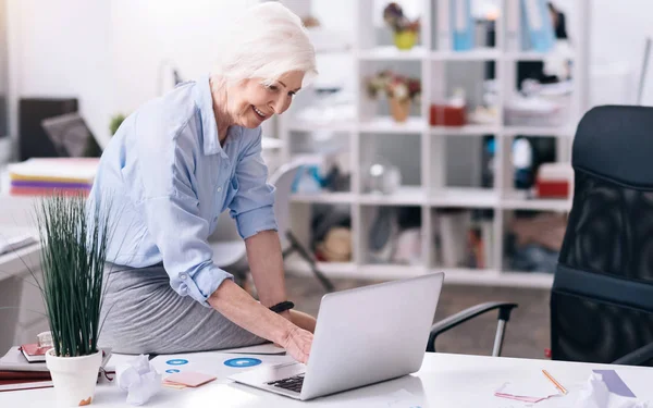 Veselý ve věku podnikatelka používat přenosný počítač v kanceláři — Stock fotografie