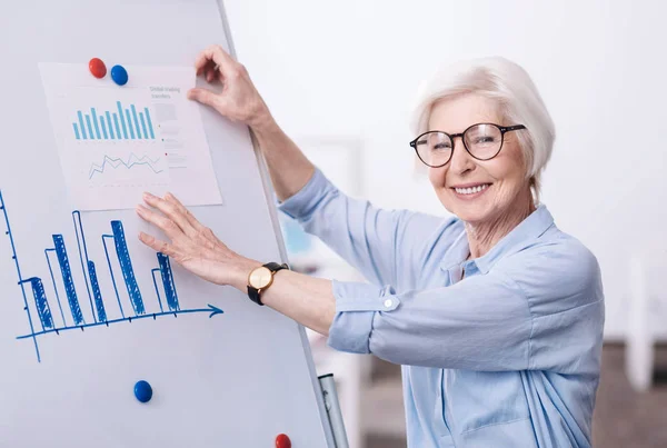 Encantadora mujer de negocios envejecida que trabaja en el proyecto en la oficina —  Fotos de Stock