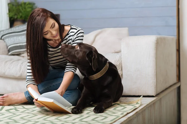 Anbud uppmärksam kvinna visar något till hennes Labrador — Stockfoto