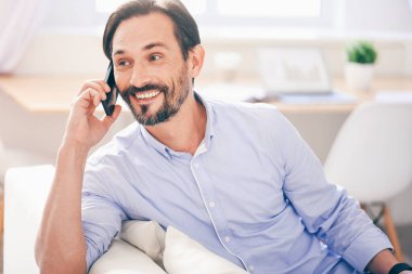 Adam cep telefonuyla konuşuyor.