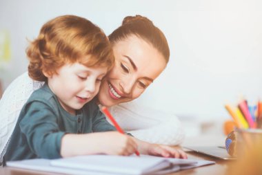 Gülümseyen Anne oğlunu yazmak için öğretim