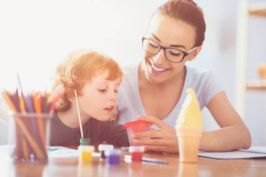 Genç anne ve yürümeye başlayan çocuk oğlu birlikte boyama