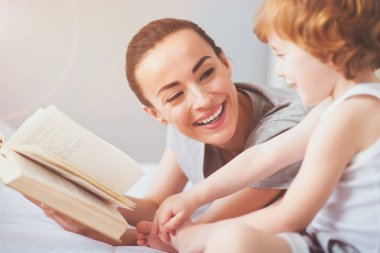 Gülen kadın oğluna bir kitap okuma