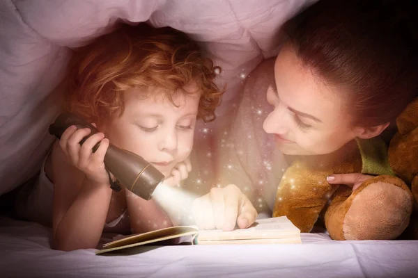 Mutlu anne ve oğlu uyumadan önce kitap zevk — Stok fotoğraf
