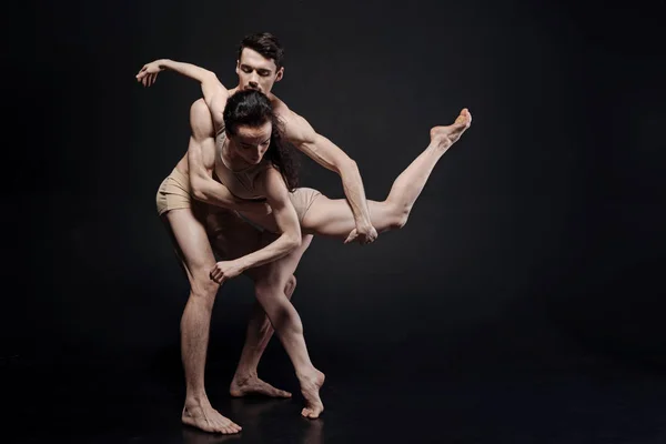Bailarines expertos actuando frente a la pared oscura — Foto de Stock