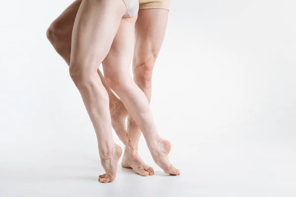 Gespierde ballet dansers benen in de witte studio — Stockfoto