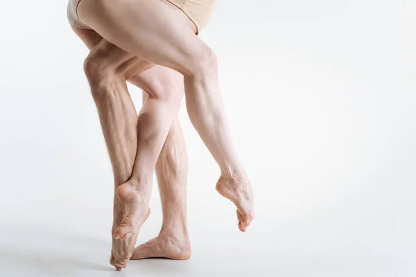 Fuertes piernas de gimnasia ubicadas en el estudio de color blanco — Foto de Stock