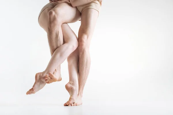 Flexibles bailarines piernas que actúan en la habitación de color blanco —  Fotos de Stock