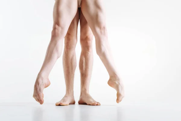 Tensed athletes legs performing in the white colored room — Stock Photo, Image