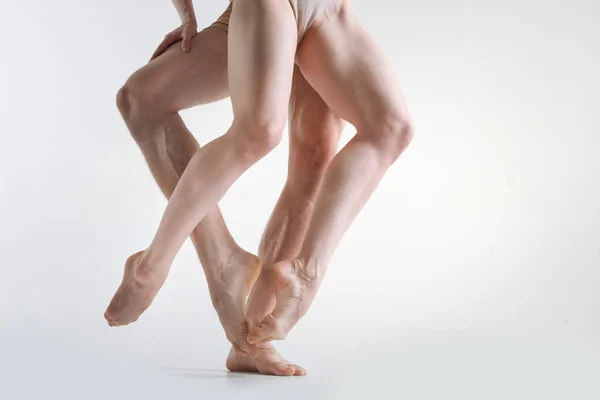 Muscular athletes legs dancing in the white colored studio — Stock Photo, Image