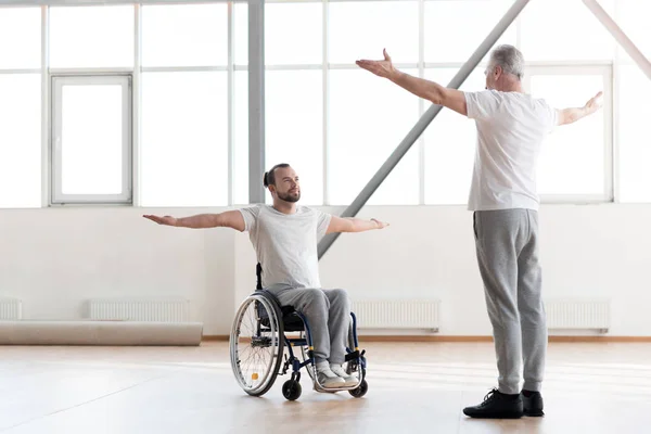 Guapo discapacitado hombre entrenamiento en el gimnasio con el ortopedista — Foto de Stock
