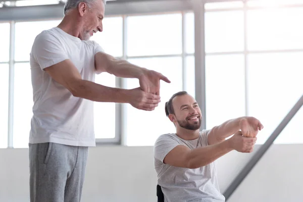 Profissional fisioterapeuta exercitando com o homem com deficiência — Fotografia de Stock