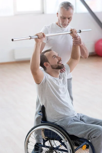 Meesterlijke leeftijd huisarts opleiding de gehandicapten in de sportschool — Stockfoto