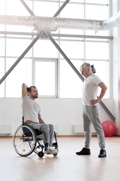 Entrenador atlético entrenar al joven discapacitado en el gimnasio — Foto de Stock