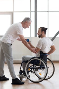 Neşeli Engelli adam ile onun teknik direktörü spor salonunda egzersiz