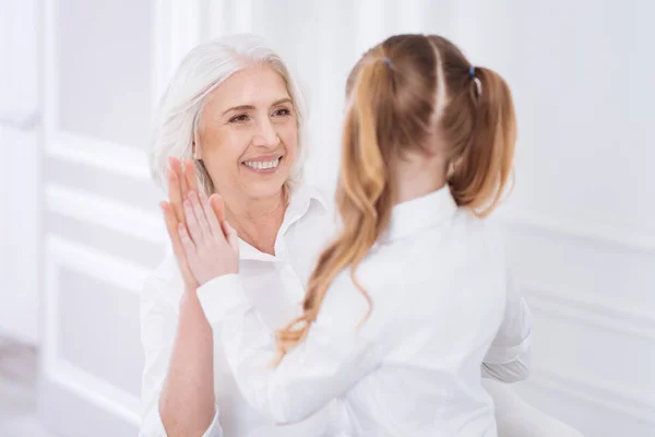 Fröhliche Frau und kleines Mädchen klatschen in die Hände — Stockfoto