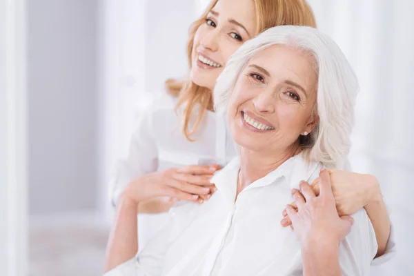 Ceerful aged woman embracing with her daughter — Stock Photo, Image