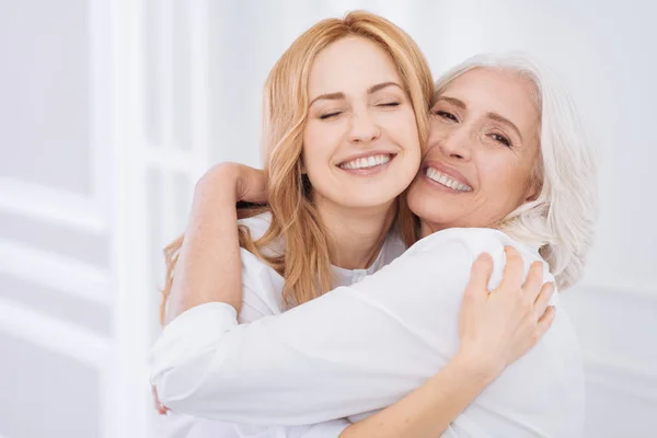 Fröhliche Seniorin und ihre Tochter umarmen sich — Stockfoto