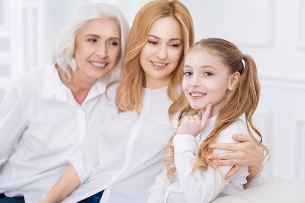 Kleines lächelndes Mädchen, das bei seiner Mutter und Großmutter ruht — Stockfoto