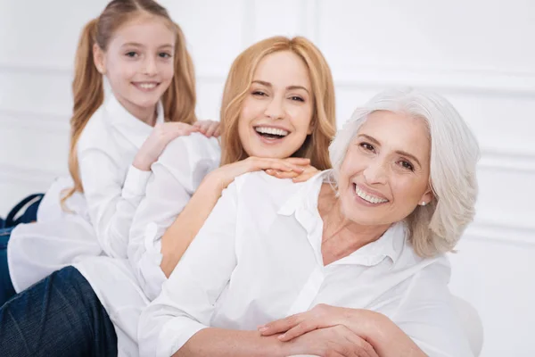 Cheerful family members sitting on the couch — Stock Photo, Image