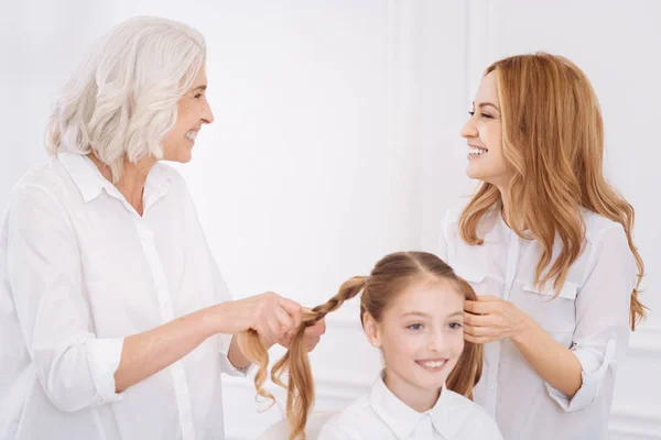 Moeder en grootmoeder haar van meisje in een vlecht maken — Stockfoto