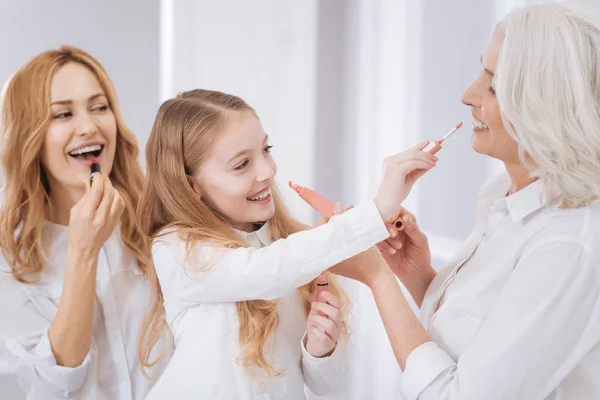 Anggota keluarga yang ceria menggunakan kosmetik — Stok Foto