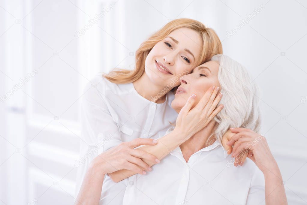 Cheerul delighted woman embracing her mother