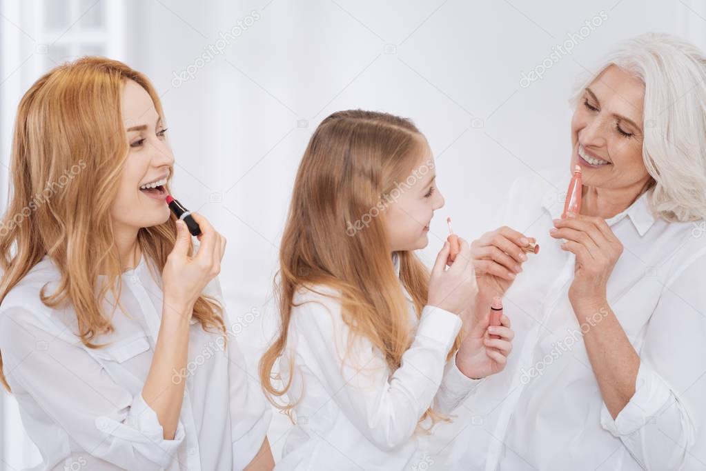 Cheerful female family members using cosmetics