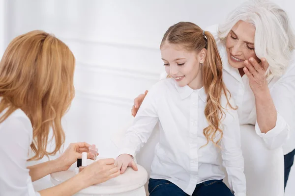 Positieve moeder schilderij nagels van haar dochtertje — Stockfoto