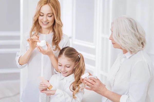 Joyful smiling family members using cosmetics — Stock Photo, Image