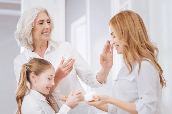 Positieve vrouwelijke familieleden uisn gbeauty crèmes — Stockfoto