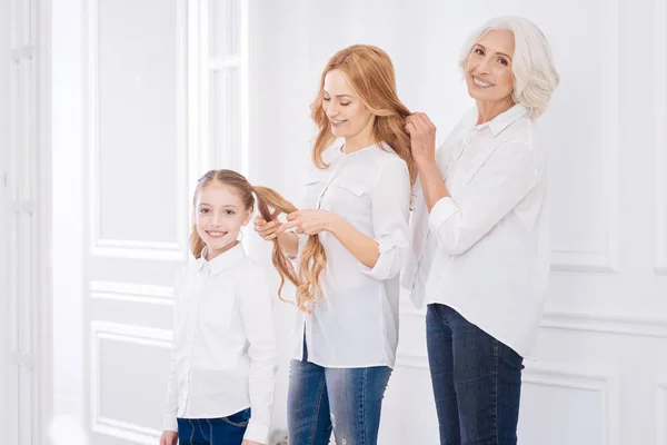 Positive Familienmitglieder, die sich gegenseitig Frisuren machen — Stockfoto