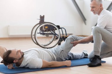 Engelli birey spor salonunda uzanan dost ortopedi uzmanı