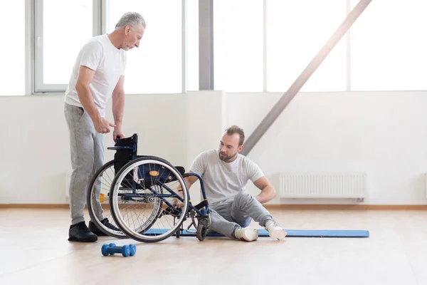 Orthopédiste impliqué travaillant avec un patient handicapé dans la salle de gym — Photo