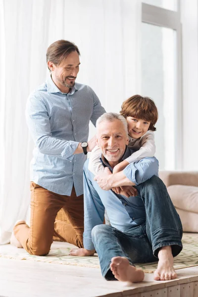 Happy young boy hugging his grandfather — Stock Photo, Image