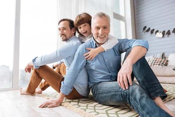 Knappe vrolijke mannen zittend op de vloer — Stockfoto