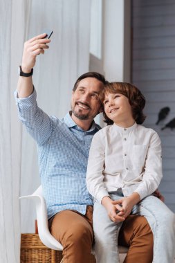 Bir akıllı telefon tutarak olumlu yakışıklı adam