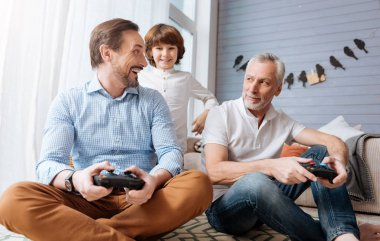 Happy delighted man holding a game console clipart