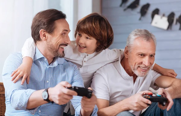 Agradables hombres encantados sosteniendo consolas de juegos — Foto de Stock