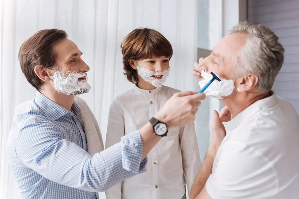 Man helping his father to shave — Stock Photo, Image