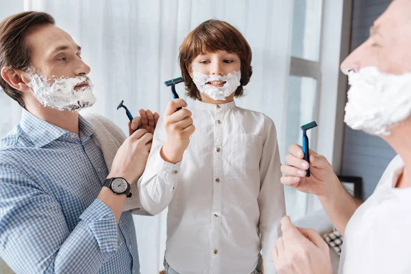 Agradables hombres encantados sosteniendo máquinas de afeitar —  Fotos de Stock