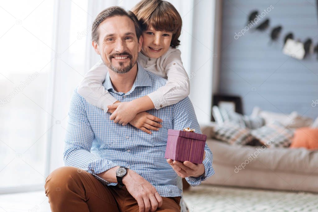 Handsome joyful man holding a gift box