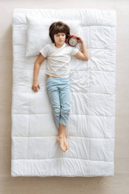 bir alarm ile yatakta yatan çocuk