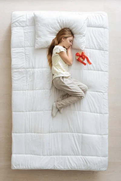 Menina bonito na cama com presente — Fotografia de Stock