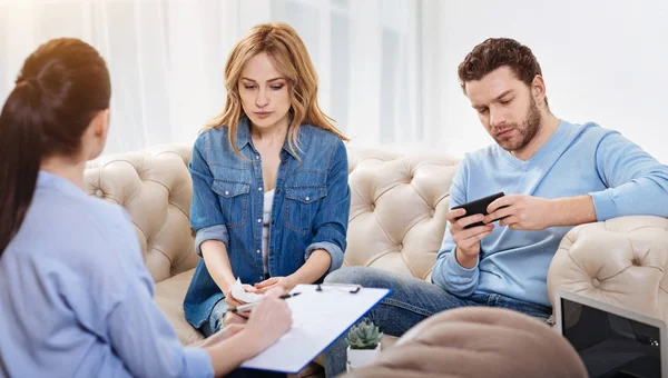 Serious calm man holding his smartphone