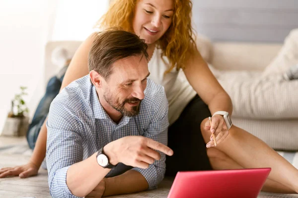 Casal positivo inspirador trabalhando juntos em casa — Fotografia de Stock